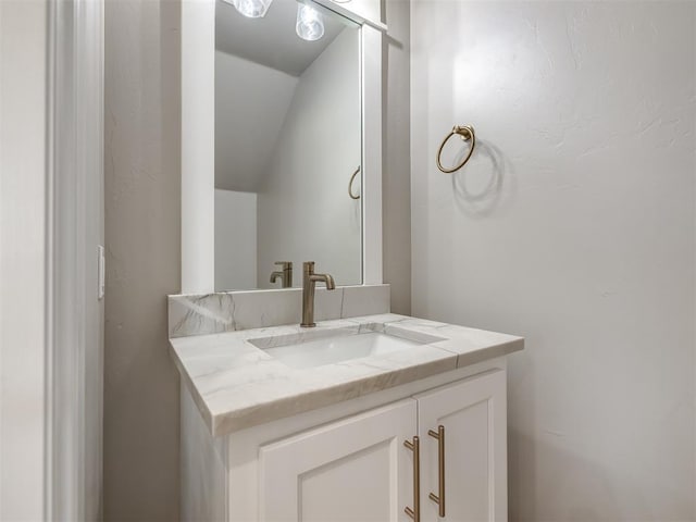 bathroom featuring lofted ceiling and vanity