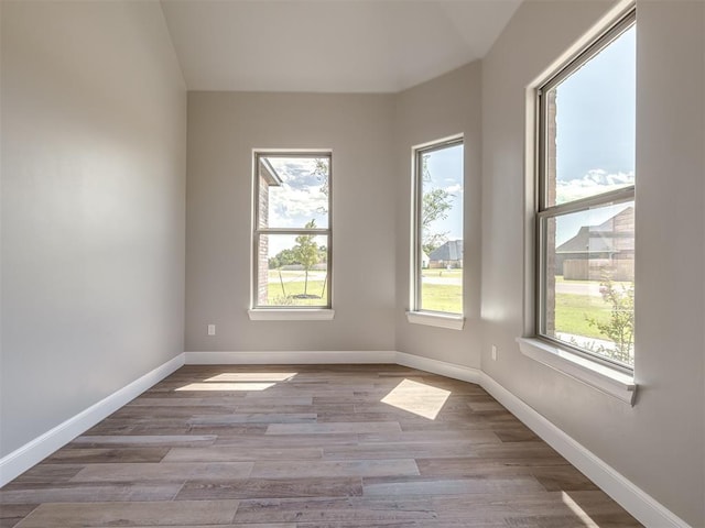 empty room featuring baseboards and wood finished floors