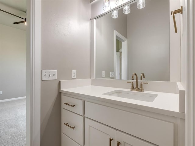 bathroom featuring baseboards, a ceiling fan, and vanity