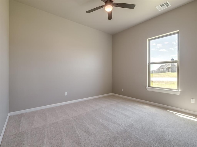 empty room with a ceiling fan, visible vents, light carpet, and baseboards