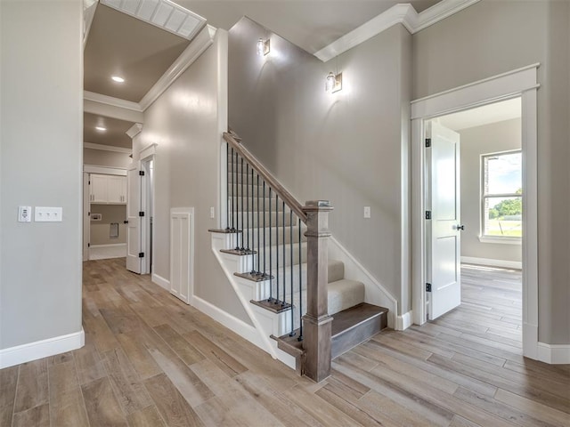 staircase with recessed lighting, crown molding, baseboards, and wood finished floors