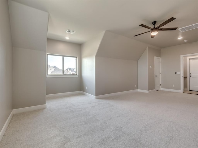 bonus room with a ceiling fan, light colored carpet, visible vents, and baseboards