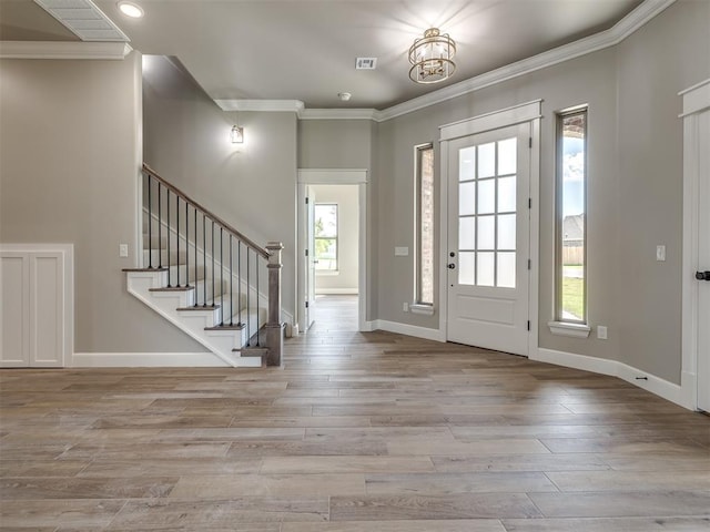 foyer with baseboards, stairway, wood finished floors, and ornamental molding