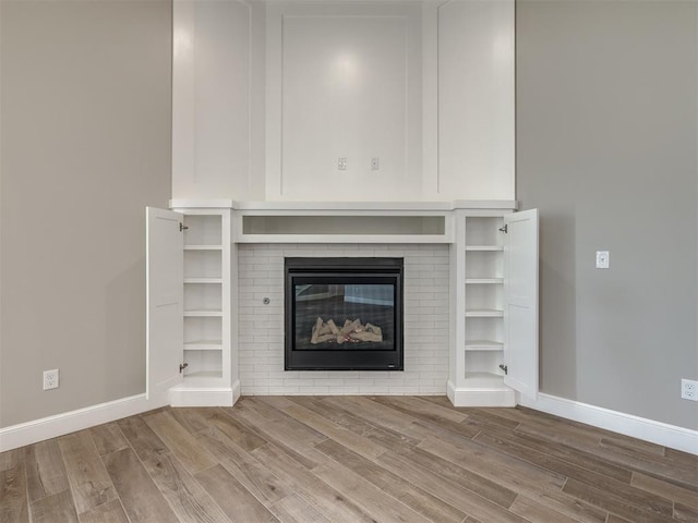 details with a fireplace, baseboards, and wood finished floors