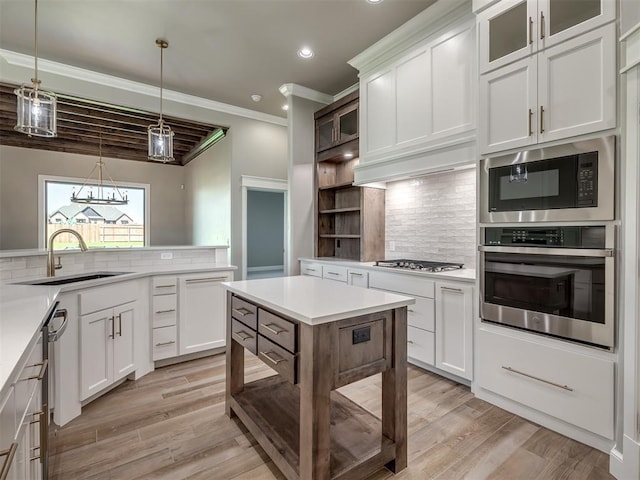 kitchen with backsplash, stainless steel appliances, a sink, and light countertops