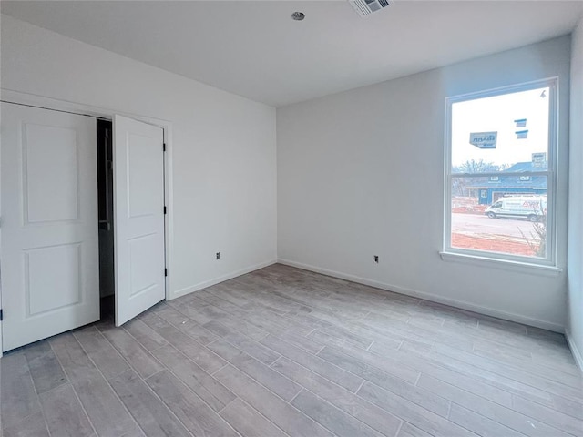 unfurnished bedroom featuring light wood-type flooring and baseboards