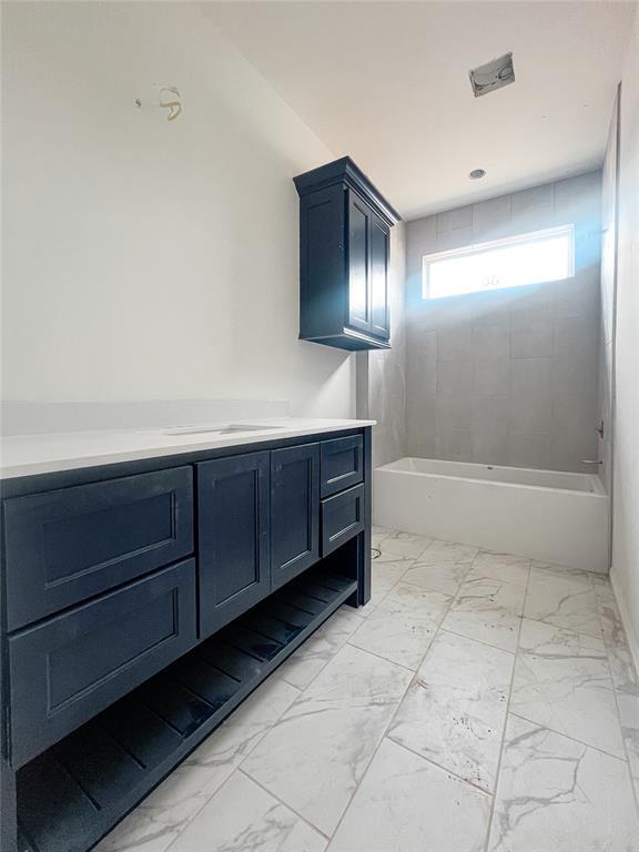 full bath featuring vanity and marble finish floor