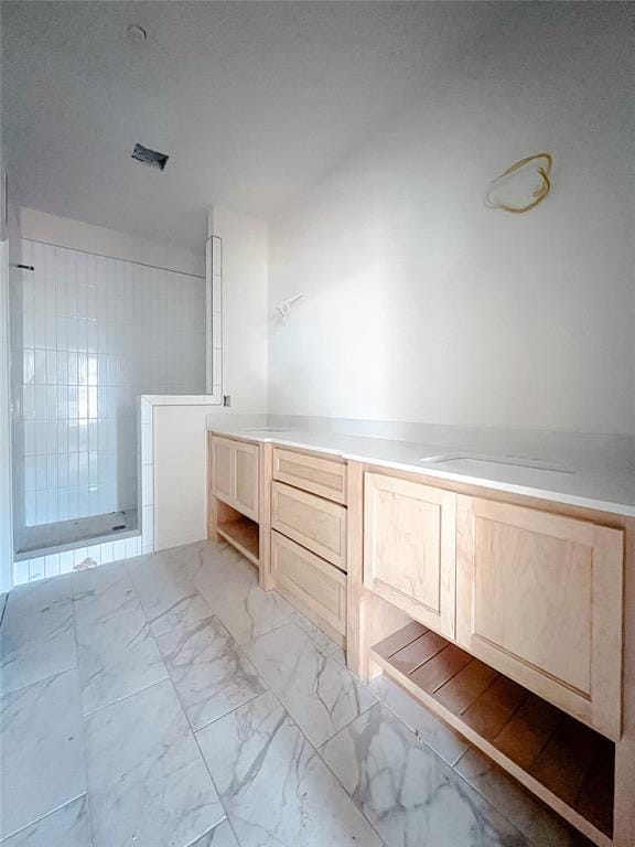 bathroom with tiled shower and marble finish floor