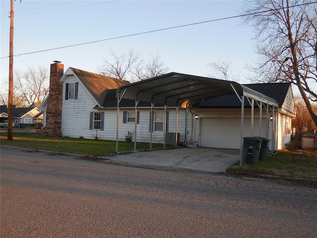 view of front of home with a garage and a carport