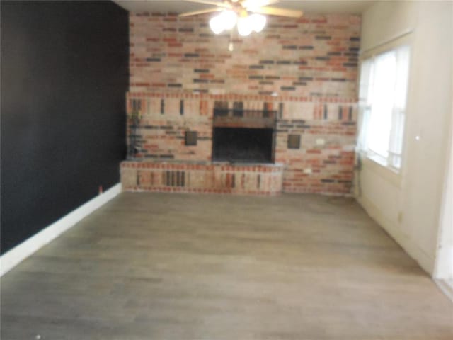 unfurnished living room with ceiling fan and a fireplace