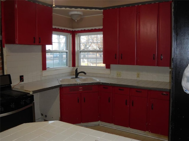 kitchen with electric range, tasteful backsplash, and sink