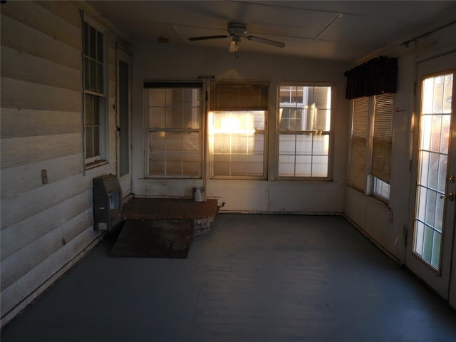 unfurnished sunroom with ceiling fan, lofted ceiling, and heating unit