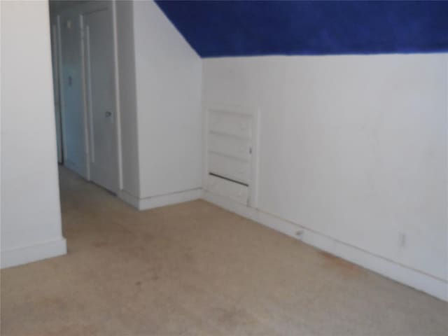 bonus room featuring light carpet and vaulted ceiling