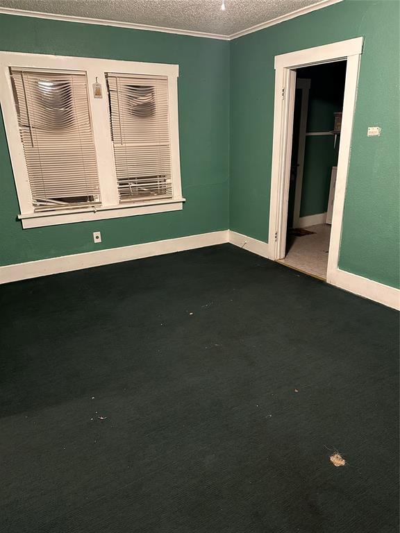 spare room with a textured ceiling and crown molding