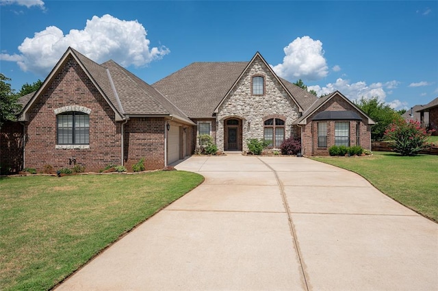 french country style house with a garage and a front yard