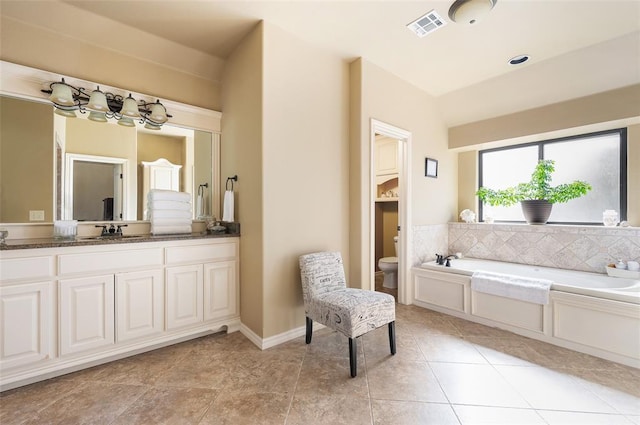 bathroom featuring a tub to relax in, tile patterned floors, vanity, and toilet