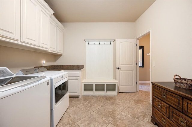 laundry area with separate washer and dryer, light tile patterned floors, and cabinets