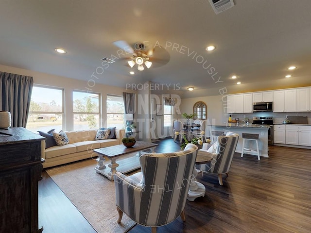 living room featuring ceiling fan and dark wood-type flooring