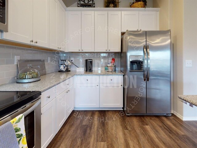 kitchen with tasteful backsplash, white cabinetry, dark wood-type flooring, and appliances with stainless steel finishes