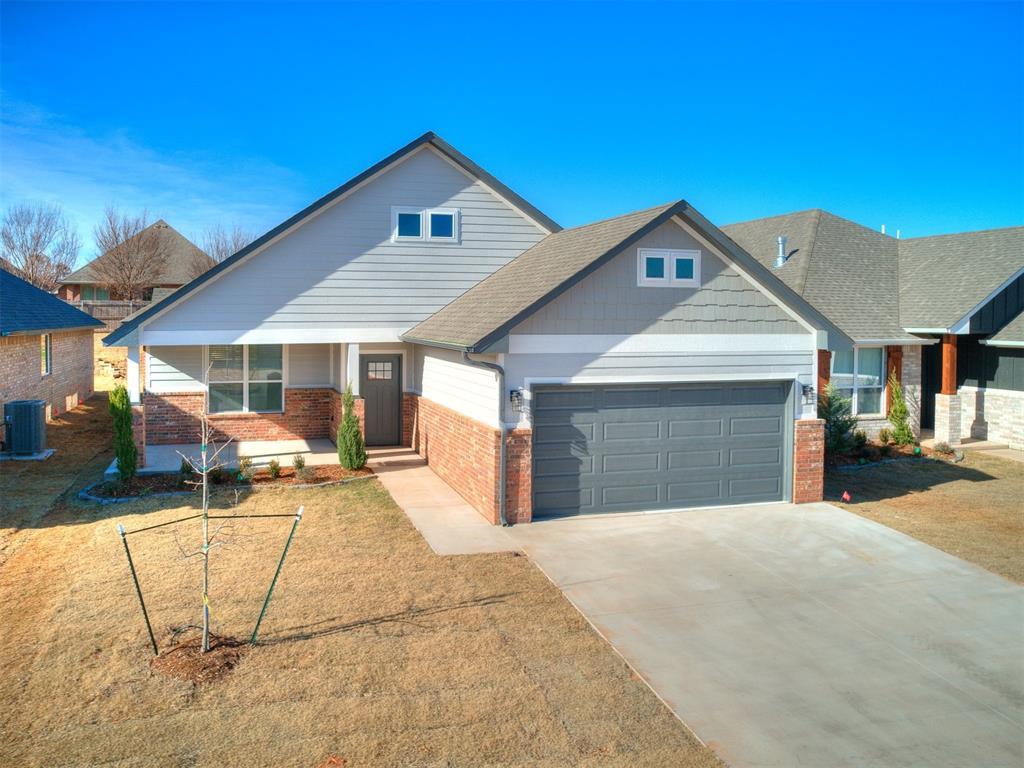 craftsman-style house with cooling unit, a garage, and a front lawn