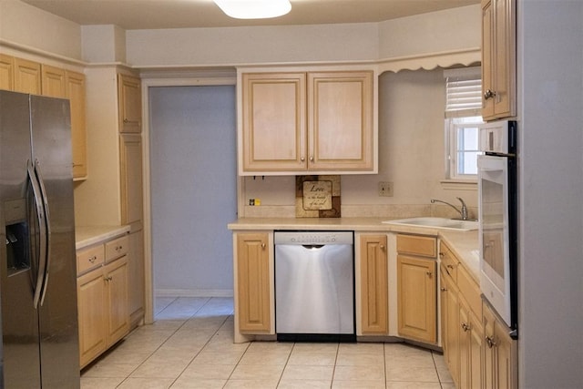 kitchen featuring sink, light brown cabinets, light tile patterned floors, and stainless steel appliances