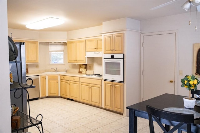 kitchen with ceiling fan, sink, white appliances, light brown cabinets, and light tile patterned floors