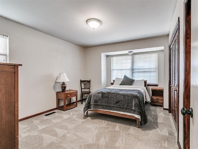 bedroom with light colored carpet and multiple windows