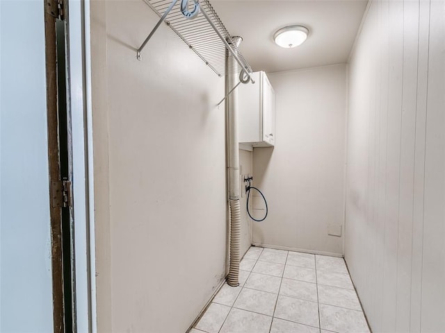 clothes washing area featuring light tile patterned floors, hookup for a washing machine, and cabinets