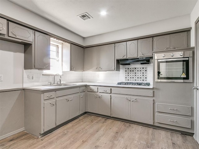 kitchen featuring gray cabinetry, sink, stainless steel appliances, and light hardwood / wood-style floors