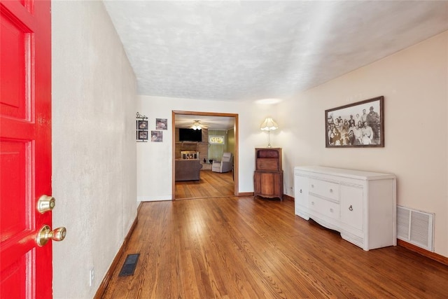 entrance foyer featuring a large fireplace, ceiling fan, and hardwood / wood-style floors