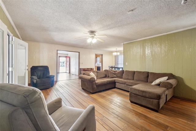 living room featuring light hardwood / wood-style floors, ornamental molding, and a textured ceiling