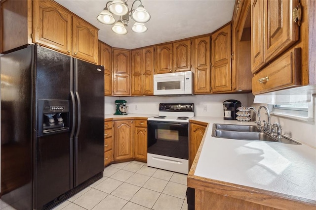 kitchen with sink, light tile patterned floors, a chandelier, and white appliances