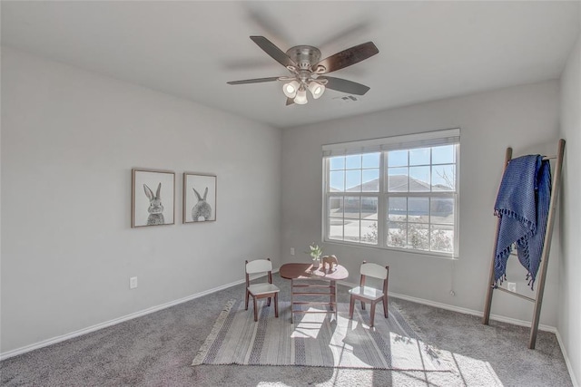 dining area with ceiling fan and light colored carpet