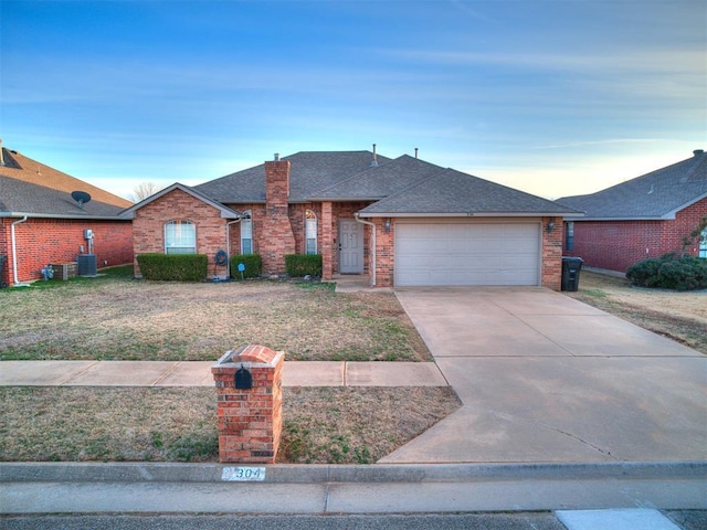 ranch-style house featuring cooling unit, a garage, and a front yard