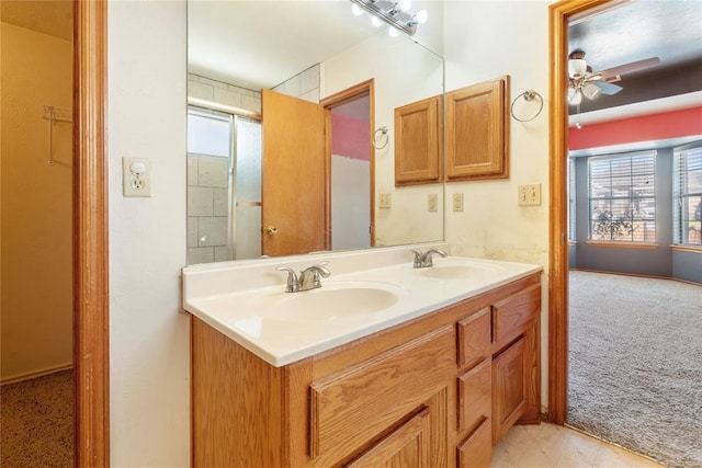 bathroom featuring vanity, ceiling fan, a shower with shower door, and a wealth of natural light