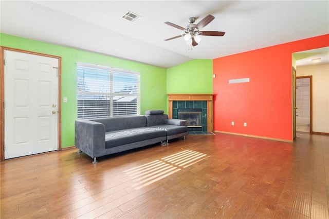 living room with ceiling fan, wood-type flooring, lofted ceiling, and a fireplace