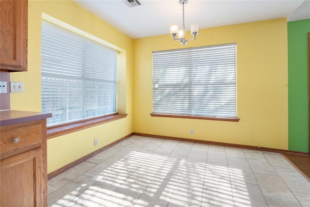 unfurnished dining area featuring a chandelier and light tile patterned flooring