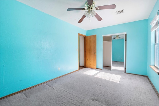 unfurnished bedroom featuring ceiling fan, a closet, and light colored carpet