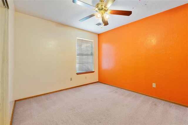 carpeted spare room featuring ceiling fan