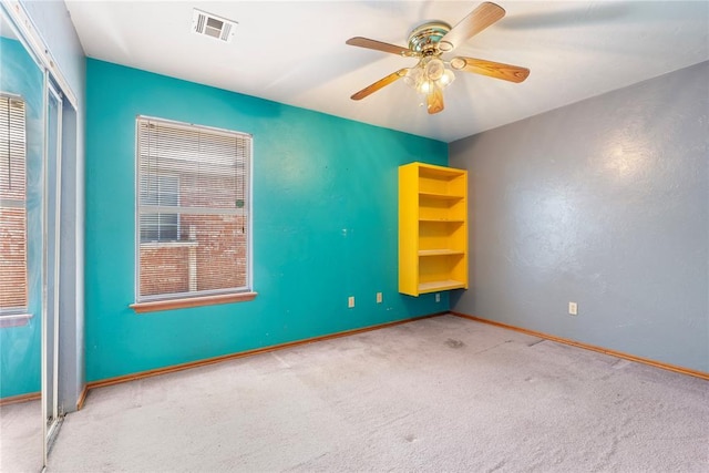 carpeted spare room with ceiling fan