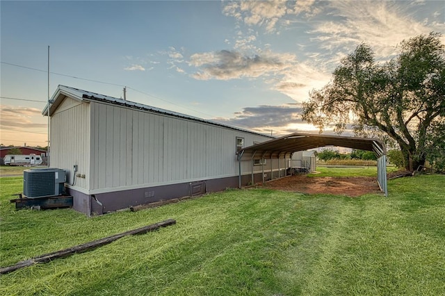 property exterior at dusk with a carport, central air condition unit, and a yard