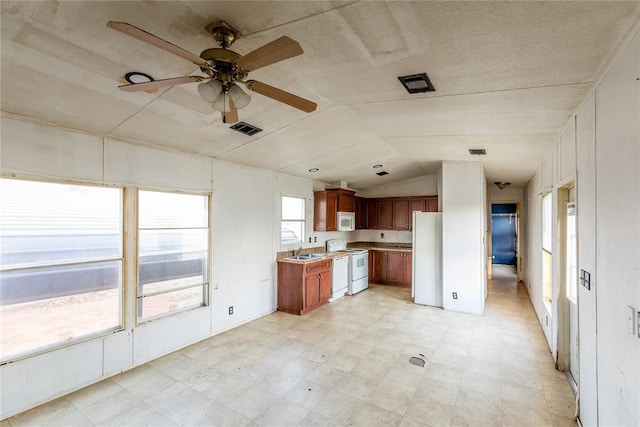 kitchen with white appliances, vaulted ceiling, ceiling fan, and sink