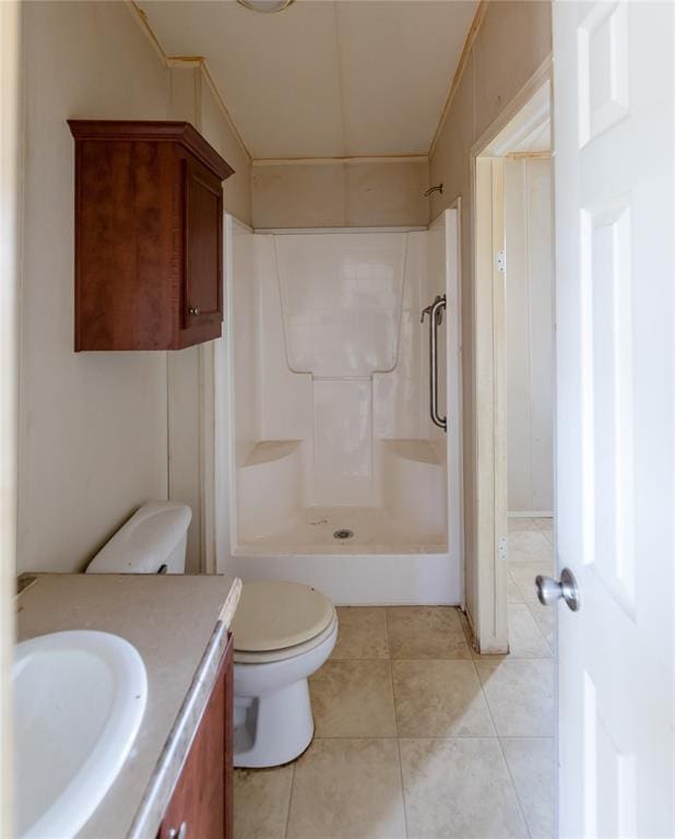 bathroom featuring tile patterned floors, vanity, toilet, and walk in shower