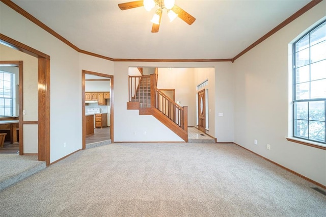 empty room featuring light carpet, ceiling fan, and ornamental molding