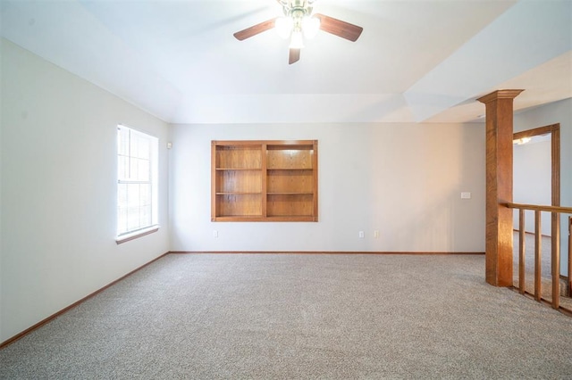 carpeted spare room with built in shelves, decorative columns, and ceiling fan