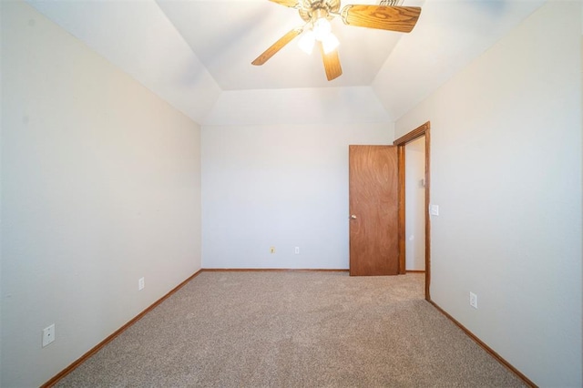 carpeted spare room with ceiling fan and vaulted ceiling