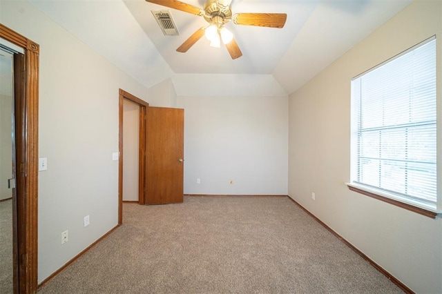 spare room featuring ceiling fan, light colored carpet, and vaulted ceiling