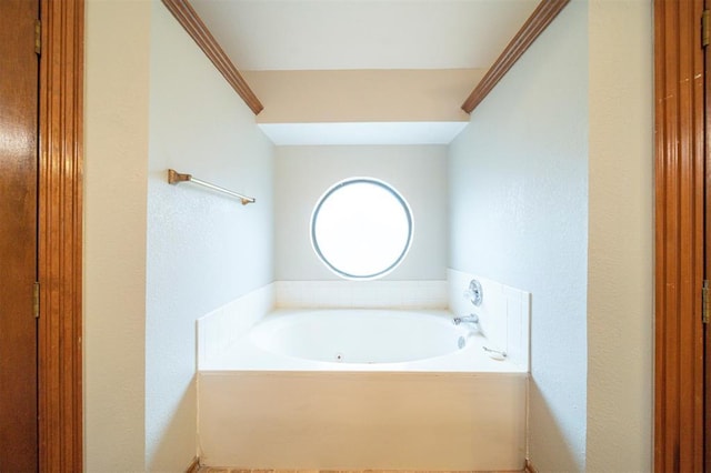 bathroom featuring a tub to relax in and ornamental molding