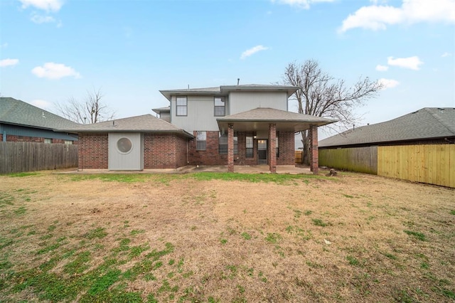 rear view of house featuring a patio area and a yard