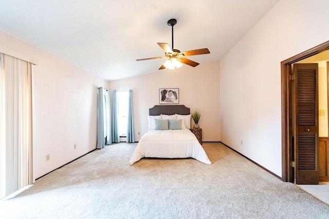 unfurnished bedroom with ceiling fan, light colored carpet, and vaulted ceiling